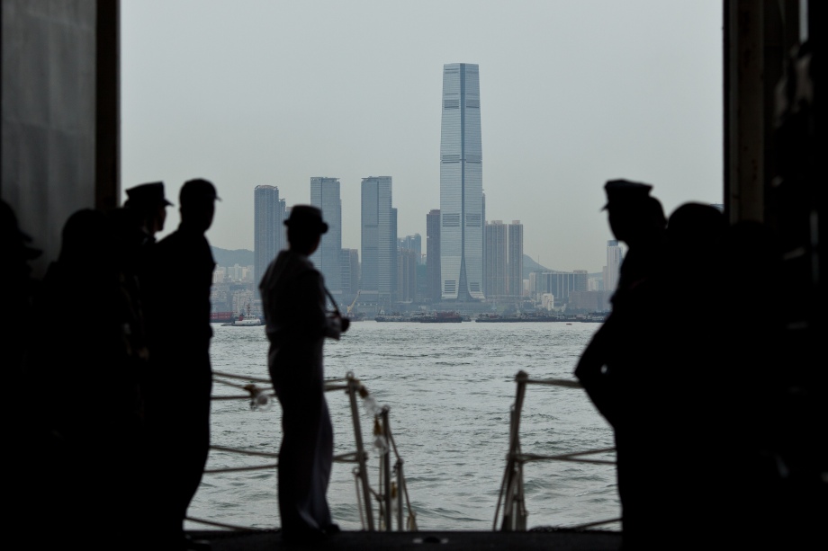 US Navy personnel on board the USS Makin Island look towards the ICC building (C) in Hong Kong on August 20, 2014. Makin Island (LHD-8) a Wasp-class amphibious assault ship and the second ship of the US Navy to be named Makin Island, was laid down on February 14, 2004 by the Ingalls Shipbuilding, Pascagoula, Mississippi and was christened on 19 August 2006. AFP PHOTO / ANTHONY WALLACE
