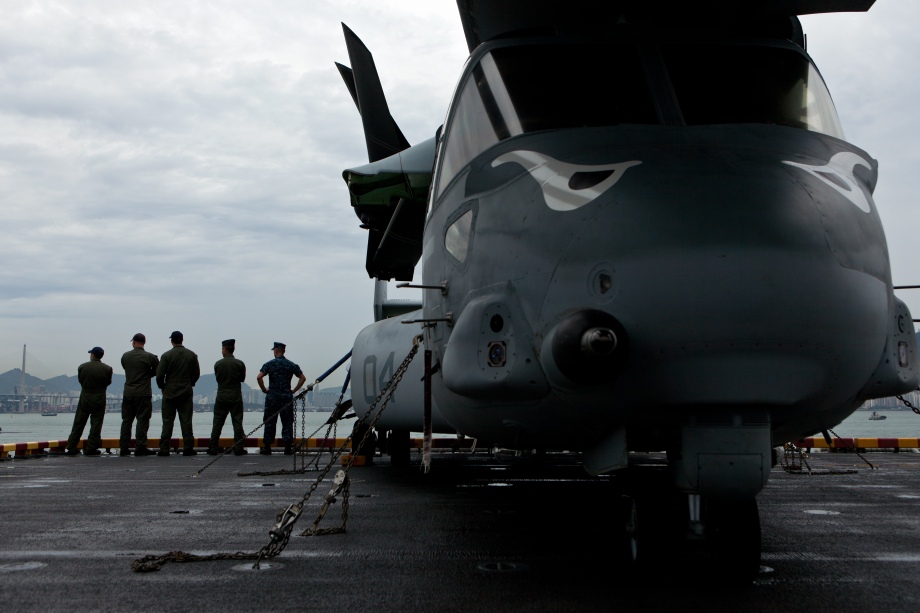 US Navy personnel on board the USS Makin Island look out towards Hong Kong on August 20, 2014. Makin Island (LHD-8) a Wasp-class amphibious assault ship and the second ship of the US Navy to be named Makin Island, was laid down on February 14, 2004 by the Ingalls Shipbuilding, Pascagoula, Mississippi and was christened on 19 August 2006. AFP PHOTO / ANTHONY WALLACE